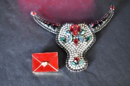 Two Butler & Wilson brooches including a rhinestone decorated Bull's Head brooch and an enamelled