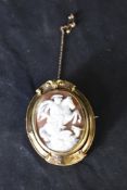 A conch shell cameo brooch depicting George and the Dragon, in a pinchbeck decorative mount with