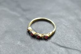A ruby and diamond chip twist ring on a 9ct gold loop, size T and approx 2.2g