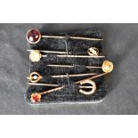 Seven assorted yellow metal stick pins including 9ct & 15ct gold