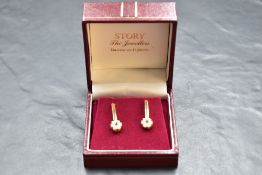 A pair of 18ct gold stud earrings having fixed bar drops to paste clusters, approx 5g gross