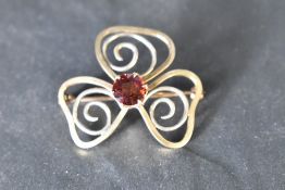 A yellow metal brooch having central garnet in open mount, no marks tests as gold, approx 8.5g