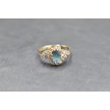 A blue topaz and diamond cluster flanked by a further trio of diamonds to each side, total approx