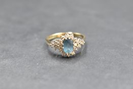 A blue topaz and diamond cluster flanked by a further trio of diamonds to each side, total approx