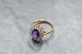 An amethyst and cubic zirconia cluster in a claw set basket mount on a 9ct gold loop, size P &