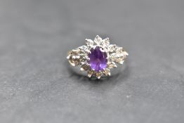 An amethyst and diamond open cluster ring with diamond set shoulders, all in illusionary mounts,