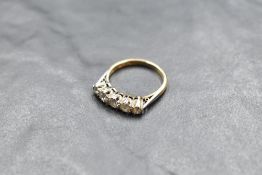 A five stone graduated diamond ring, total approx 0.5ct in a claw set mount on a yellow metal loop