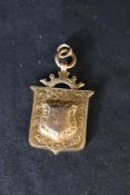 An Edwardian 9ct gold shield medallion bearing date 1908 to front, approx 8.3g