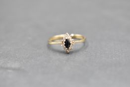 A small sapphire and diamond oval cluster ring on a 9ct gold loop, size P & approx 1.4g