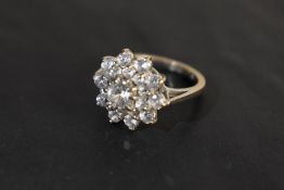 A large white stone triple cluster ring having a stepped claw set basket mount on an 18ct white gold