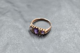 A three stone amethyst ring having diamond chip spacers in a gallery mount on a 9ct rose gold