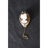 A conch cameo brooch depicting a Grecian maiden in profile, in a yellow metal decorative mount,