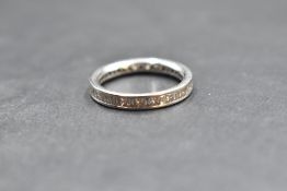 A platinum and diamond full eternity ring having alternate princess and baguette cut diamonds, total