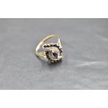 A sapphire and diamond open swirl cluster in a claw set basket mount on a 9ct gold loop, size Q &