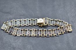 A 585 grade bi-colour metal bracelet, the pierced rectangular links finishing with a tongue and