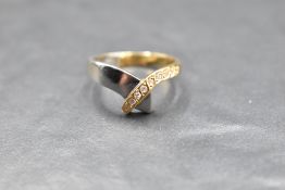 A white and yellow metal serpent style ring of plain form having clear stones (not diamonds) set