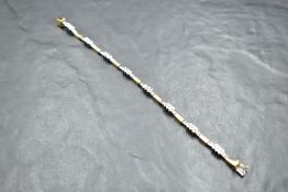 An 18ct white and yellow gold articulated bracelet having eight diamond set panels, 40 stones
