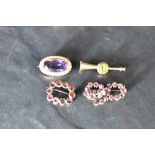 An amethyst and seed pearl brooch in a yellow metal mount, a trumpet style yellow metal brooch