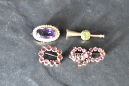 An amethyst and seed pearl brooch in a yellow metal mount, a trumpet style yellow metal brooch