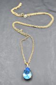 A 9ct gold pendant and chain having a pear drop shaped blue topaz in a claw set mount on a fine rope