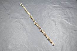A 9ct gold brick link bracelet having three topaz and diamond chip set panels and a dog leash clasp,