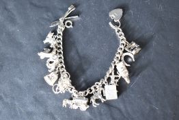A silver charm bracelet having sixteen white metal charms, most stamped silver, including vespa,