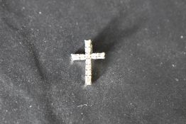 A small diamond cross pendant having brilliant and baguette cut diamonds in a 14ct white gold mount,