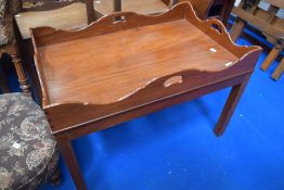 A reproduction mahogany butlers tray style side table