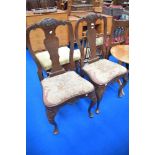 A pair of 19th Century dining chairs having vase backs, tapestry seats and cabriole legs with carved