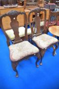 A pair of 19th Century dining chairs having vase backs, tapestry seats and cabriole legs with carved
