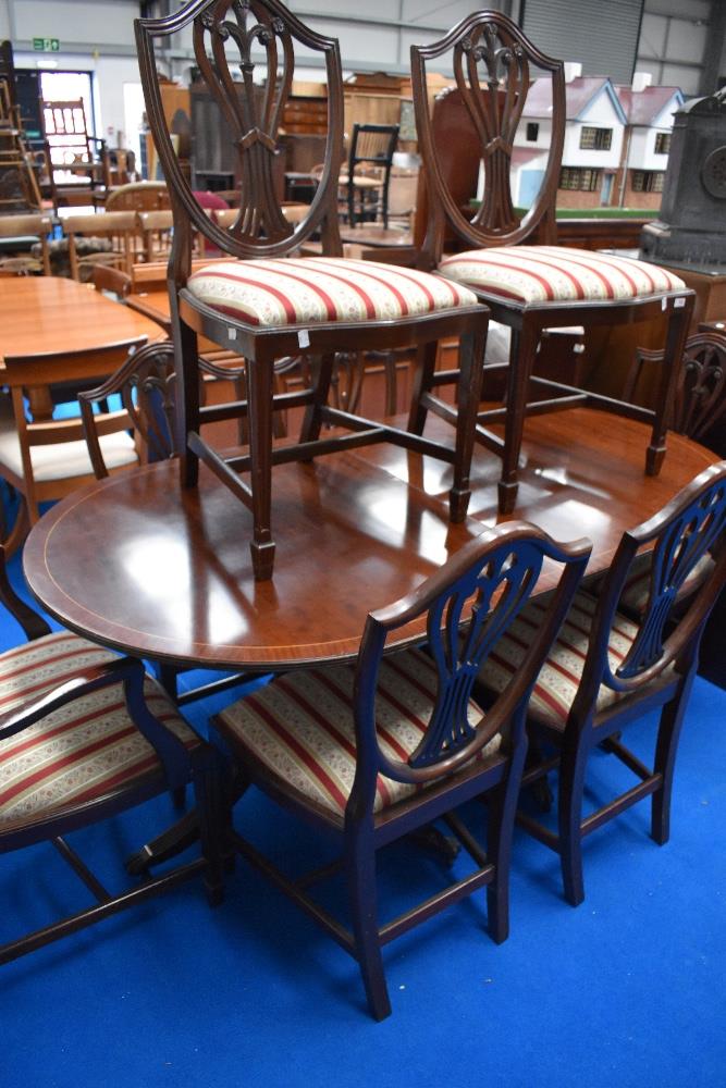 A reproduction Regency twin pedestal mahogany dining tabe and eight (six plus two) similar chairs