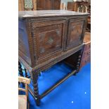A period oak cabinet on stand having carved decoration and turned legs on stile frame