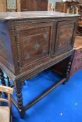 A period oak cabinet on stand having carved decoration and turned legs on stile frame