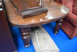 A Victorian mahogany wind out dining table on heavy fluted legs with two additional leaves