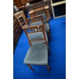 A set of four Victorian golden oak dining chairs having later upholstery
