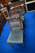 A set of four Victorian golden oak dining chairs having later upholstery