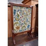 An Edwardian mahogany firescreen having tapestry panel