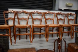 A set of six stained frame kitchen chairs having shaped rail backs and rush seats