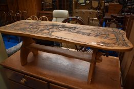 A traditional golden oak coffee table having carved ploughing decoration, width approx. 111cm