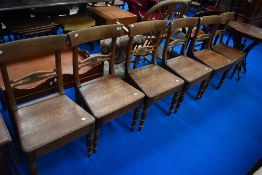 A set of six Georgian oak solid seat dining chairs having shaped rail backs