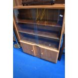 A golden oak bookcase with double cupboard under