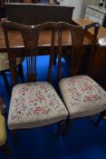 A pair of Edwardian mahogany dining chairs having inlaid feather backs