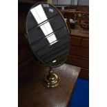 A vintage toilet mirror having brass frame and stand