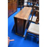 An early 20th Century oak drop leaf dining table