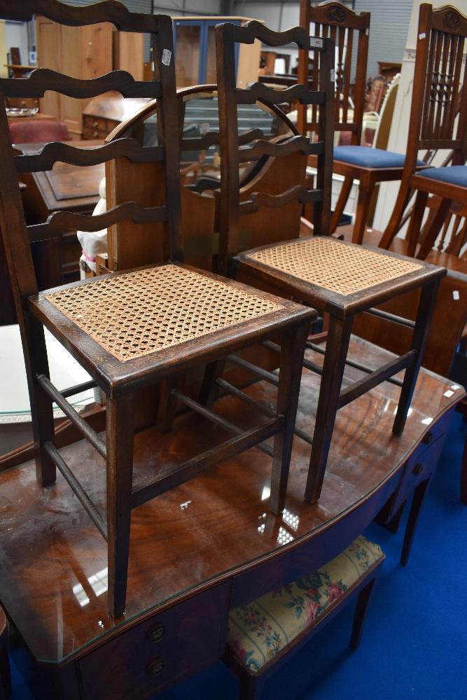 A pair of Victorian stained frame bedroom chairs having cane seats