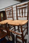 A pair of 19th Century spindle back kitchen chairs having rush seats