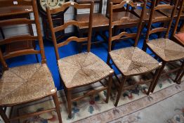 Two pairs of rush seated kitchen chairs having shaped ladder backs