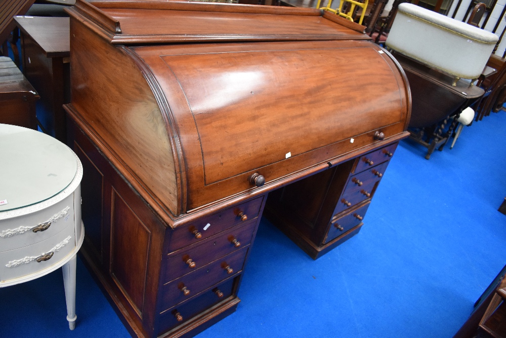 A Victorian mahogany cylinder roll top bureau desk with fitted interior and double drawer pedestals,