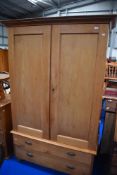 A Victorian stripped pine wardrobe on double drawer base
