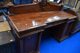 A 19th Century mahogany sideboard of large proportions having cartouche ledge back and breakfront